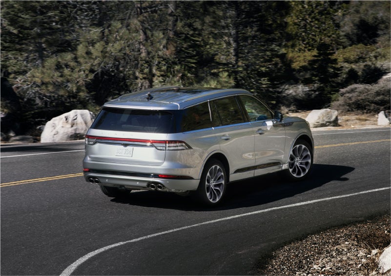 A 2023 Lincoln Aviator® Grand Touring model is shown being driven on a tight turn of a mountain road | Boulevard Lincoln in Georgetown DE