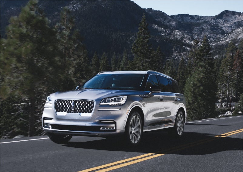 A 2023 Lincoln Aviator® Grand Touring SUV being driven on a winding road to demonstrate the capabilities of all-wheel drive | Boulevard Lincoln in Georgetown DE